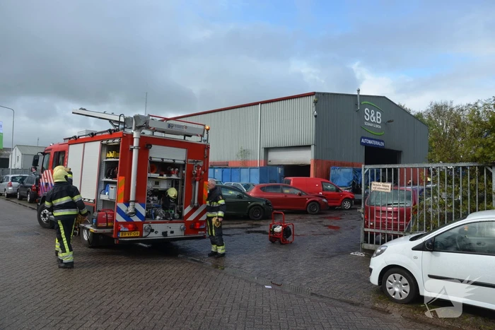Auto vat vlam in loods van bedrijf