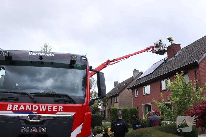 Vlammen slaan uit schoorsteen