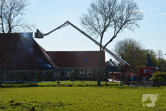 Brand in dak van woonboerderij