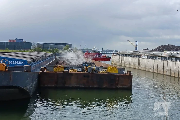 Brandweerboot inspecteert dampende duwbak