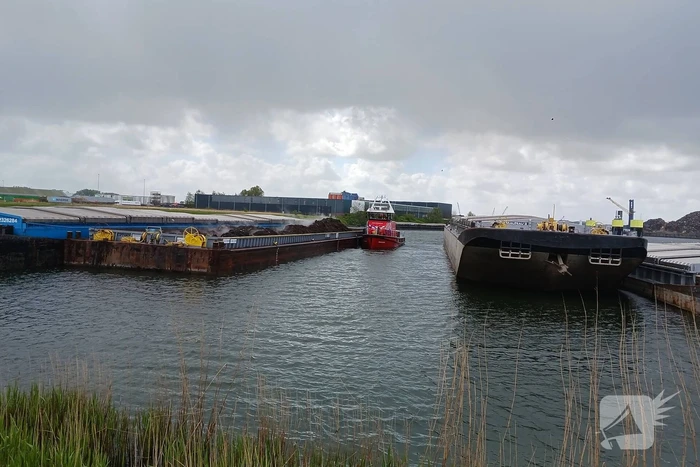 Brandweerboot inspecteert dampende duwbak