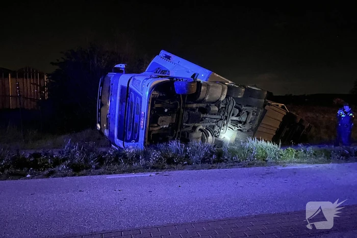 Vrachtwagen ramt boom en belandt op zijkant in sloot