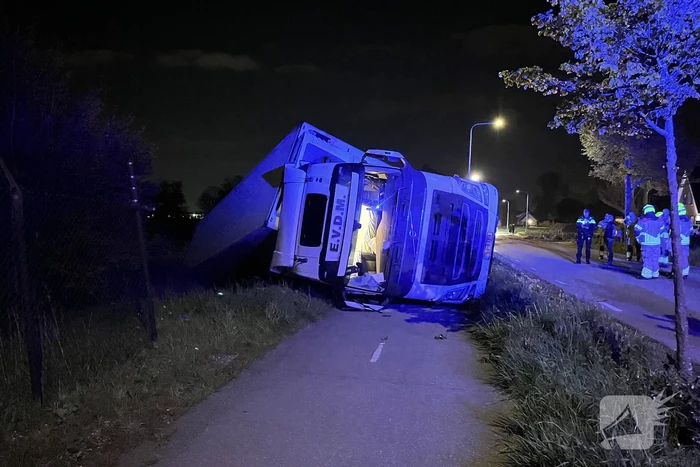Vrachtwagen ramt boom en belandt op zijkant in sloot