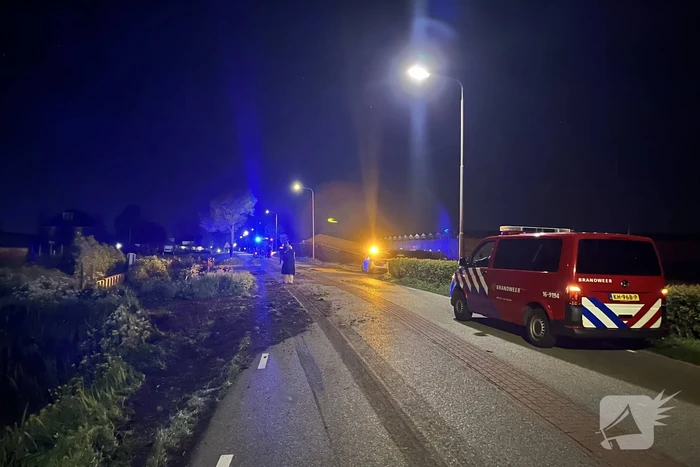 Vrachtwagen ramt boom en belandt op zijkant in sloot