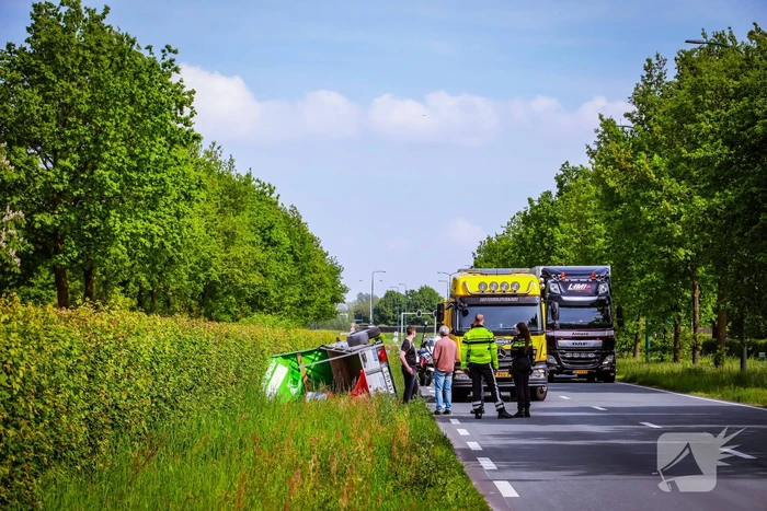 Aanhanger geladen met stenen belandt op zijn kant