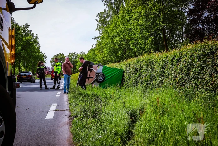 Aanhanger geladen met stenen belandt op zijn kant