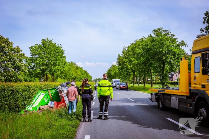 Aanhanger geladen met stenen belandt op zijn kant