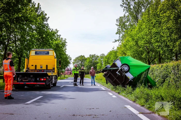 Aanhanger geladen met stenen belandt op zijn kant