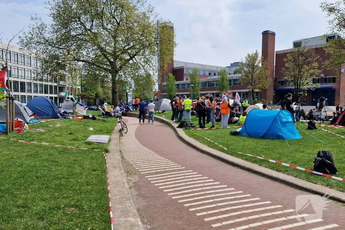 Studenten in tenten op grasveld bij UvA