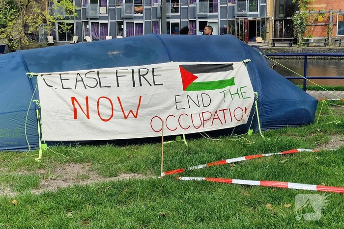 Studenten in tenten op grasveld bij UvA