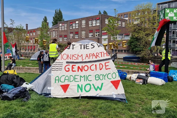 Studenten in tenten op grasveld bij UvA