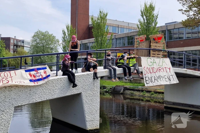 Studenten in tenten op grasveld bij UvA