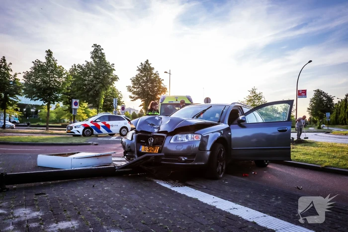 Automobilist vliegt over de rotonde botst op lantaarnpaal