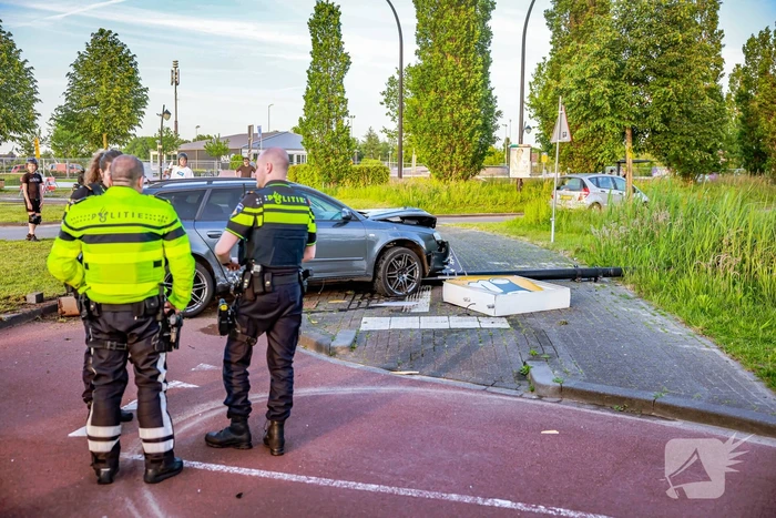 Automobilist vliegt over de rotonde botst op lantaarnpaal