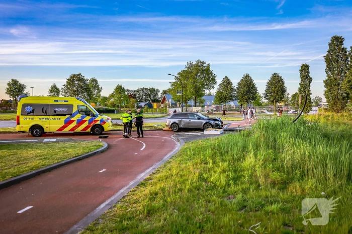 Automobilist vliegt over de rotonde botst op lantaarnpaal