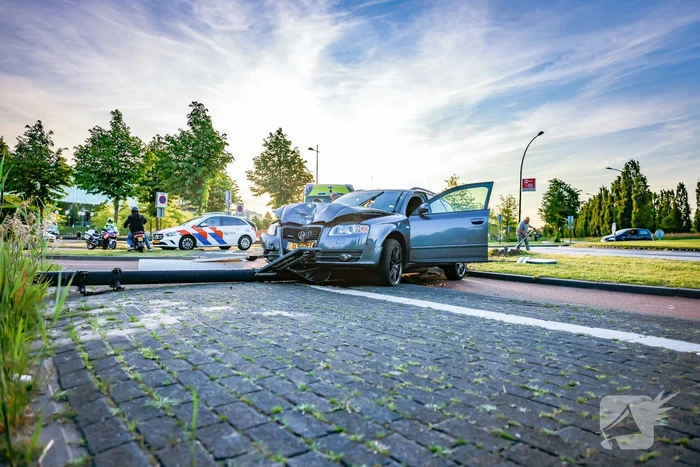 Automobilist vliegt over de rotonde botst op lantaarnpaal