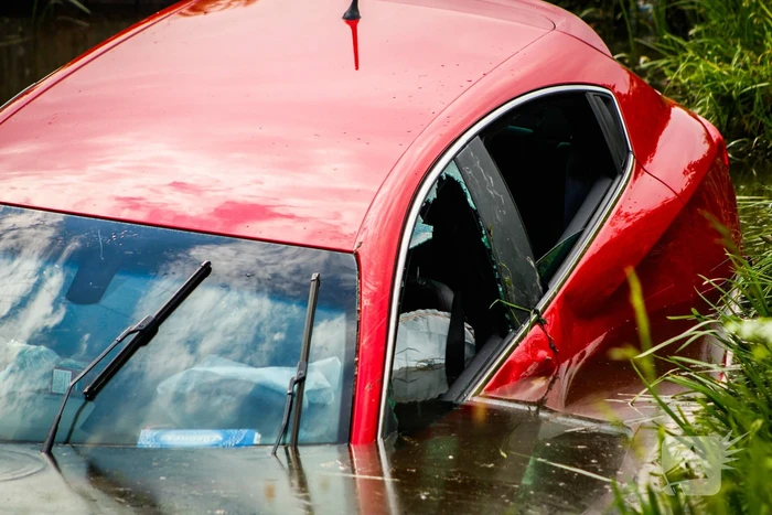 Omstanders helpen personen uit auto die te water raakte