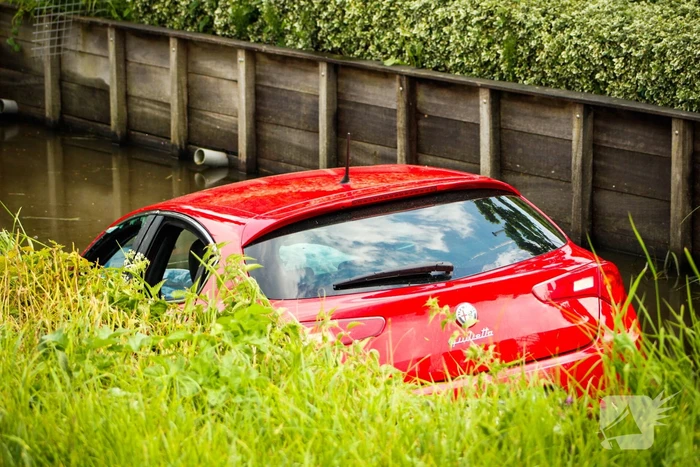 Omstanders helpen personen uit auto die te water raakte