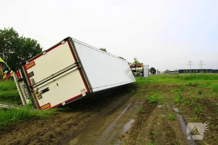 Vrachtwagen op zijn kant in sloot
