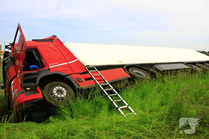 Vrachtwagen op zijn kant in sloot
