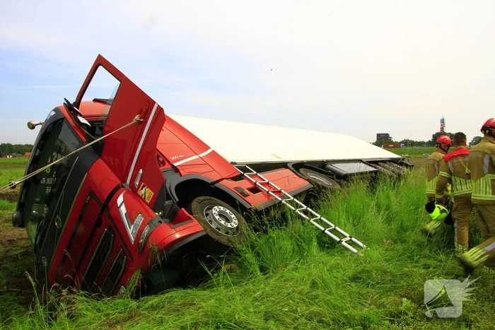 Vrachtwagen op zijn kant in sloot