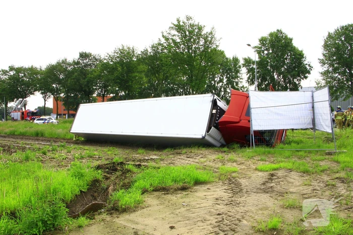 Vrachtwagen op zijn kant in sloot