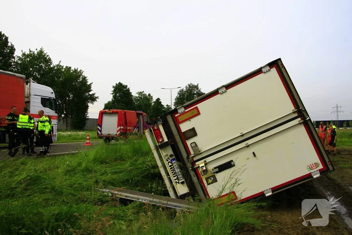 Vrachtwagen op zijn kant in sloot