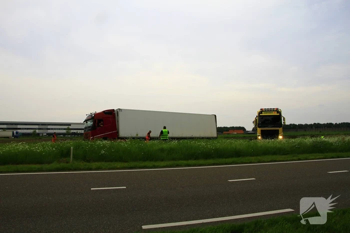 Vrachtwagen op zijn kant in sloot