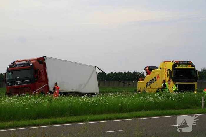 Vrachtwagen op zijn kant in sloot