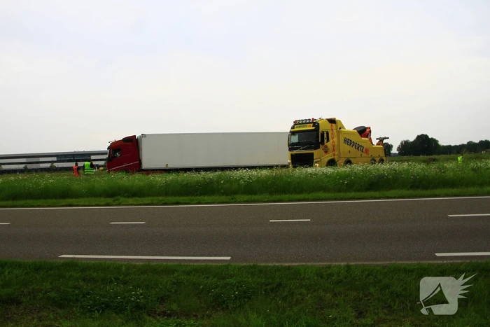 Vrachtwagen op zijn kant in sloot