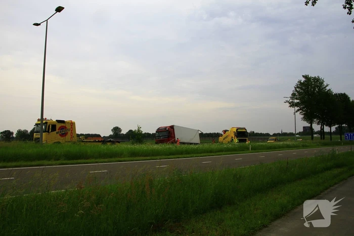 Vrachtwagen op zijn kant in sloot