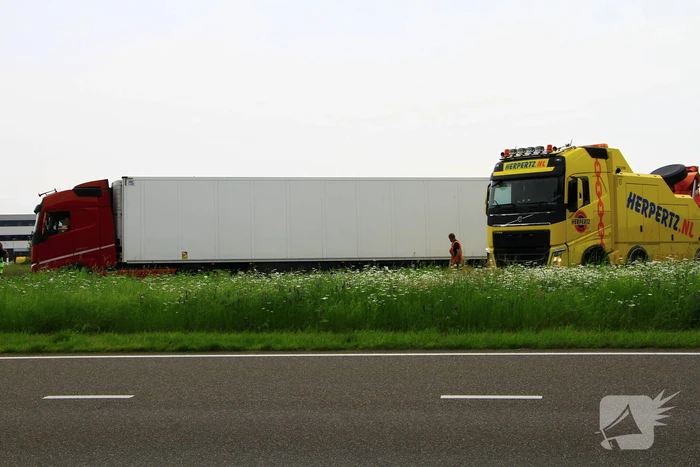 Vrachtwagen op zijn kant in sloot