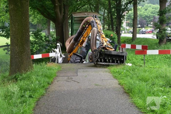 Berm maaier zakt door brug