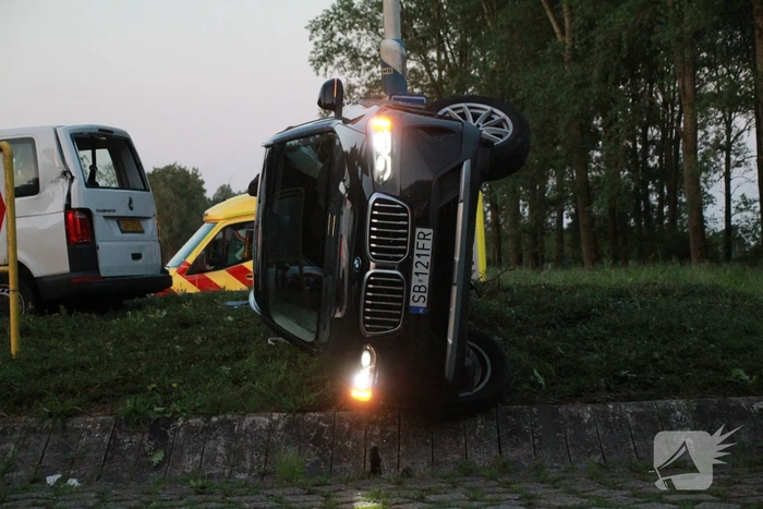 Auto op zijn kant na opmerkelijk ongeval op rotonde