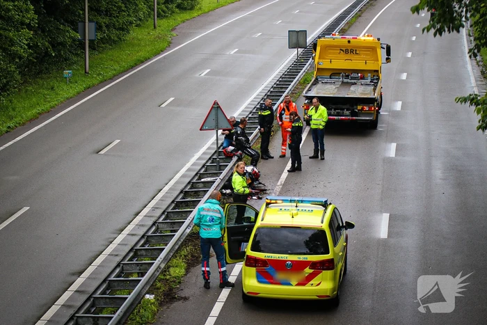 Motorrijder hard onderuit door water onder viaduct