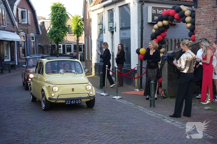 Leerlingen komen in bijzondere auto's aan bij examenfeest
