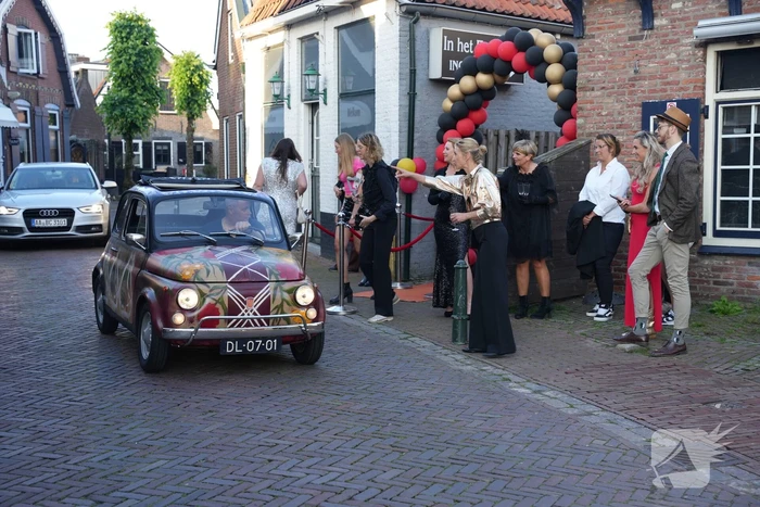 Leerlingen komen in bijzondere auto's aan bij examenfeest