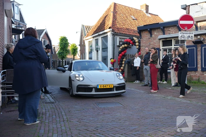 Leerlingen komen in bijzondere auto's aan bij examenfeest