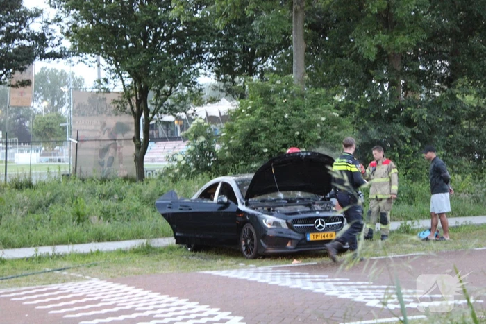 Brandweer blust brand in geparkeerde auto