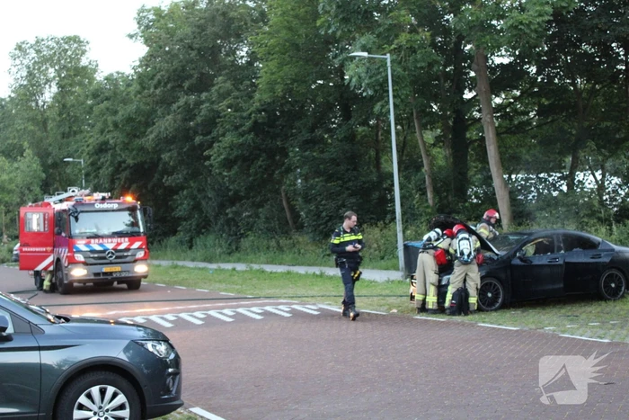 Brandweer blust brand in geparkeerde auto