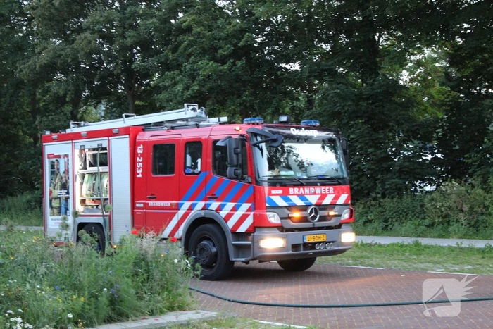 Brandweer blust brand in geparkeerde auto