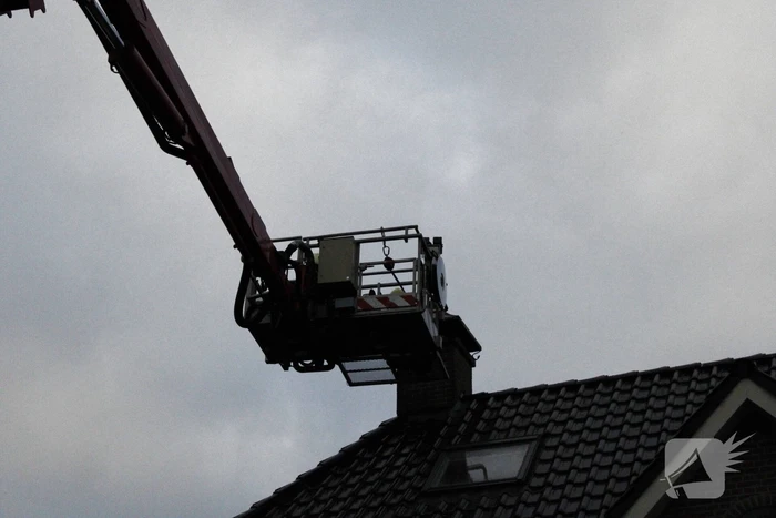 Brandweer veegt schoorsteen na brand