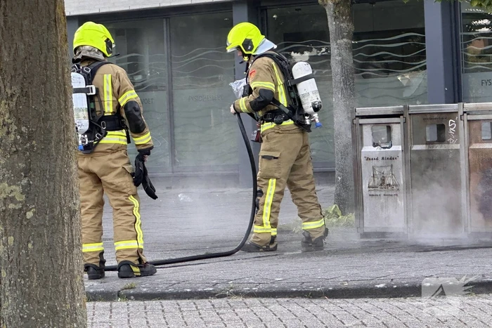 Brandweer blust brand in afvalbak