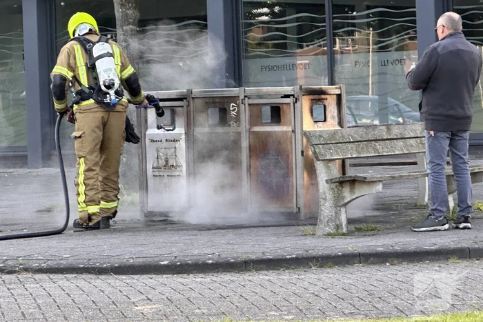 Brandweer blust brand in afvalbak