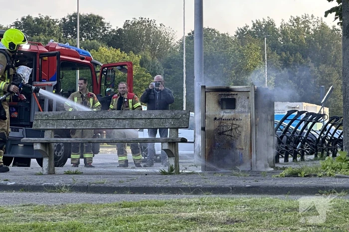 Brandweer blust brand in afvalbak
