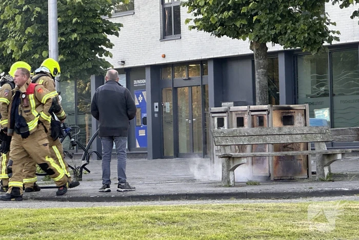 Brandweer blust brand in afvalbak