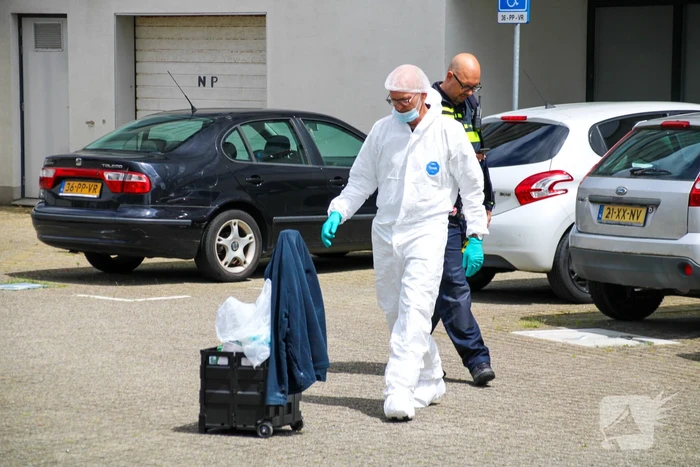 Forensisch onderzoek op parkeerplaats naast flatgebouw