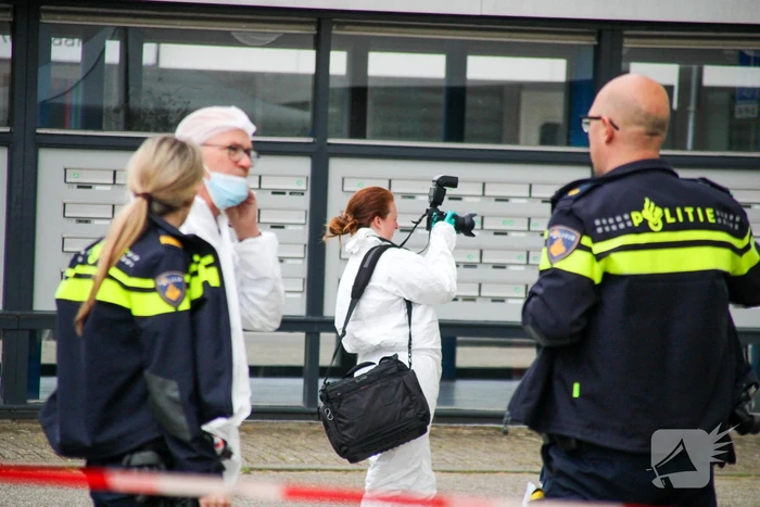 Forensisch onderzoek op parkeerplaats naast flatgebouw