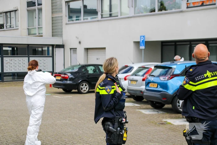 Forensisch onderzoek op parkeerplaats naast flatgebouw