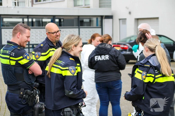 Forensisch onderzoek op parkeerplaats naast flatgebouw